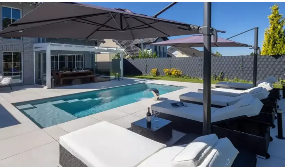 Svart rottingloungestol med vita kuddar och visuellt imponerande design